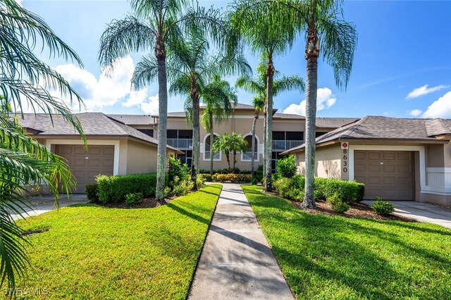 single story home featuring a front yard and a garage