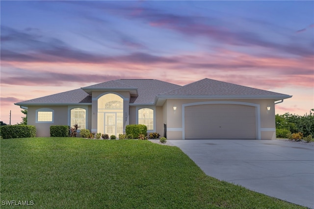 view of front of house featuring a garage and a lawn