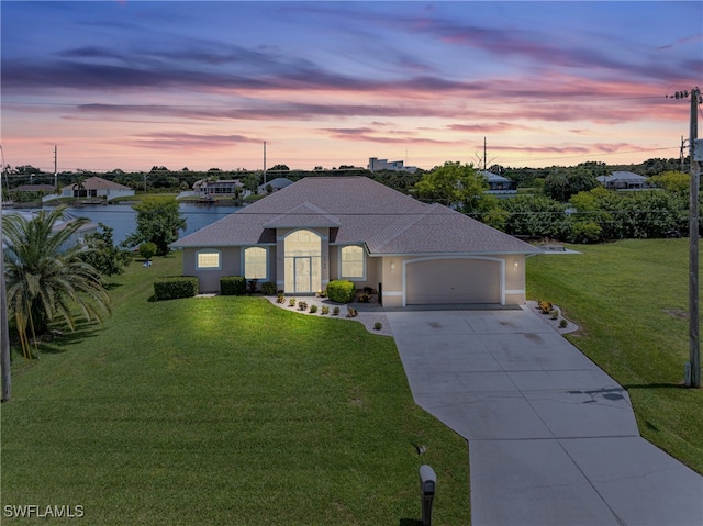 view of front of property with a garage and a yard