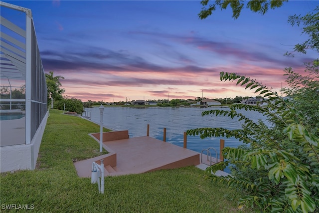 dock area with a water view, glass enclosure, and a yard