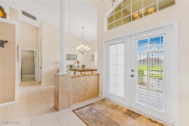 doorway to outside featuring plenty of natural light, decorative columns, high vaulted ceiling, and tile patterned floors