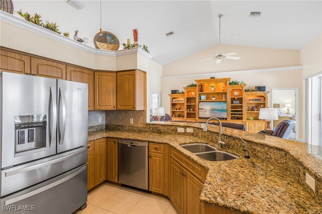 kitchen featuring decorative backsplash, ceiling fan, stone counters, sink, and stainless steel appliances