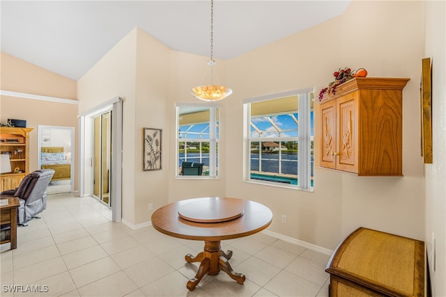 tiled dining area featuring vaulted ceiling and a chandelier