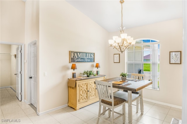 tiled dining area featuring an inviting chandelier and vaulted ceiling