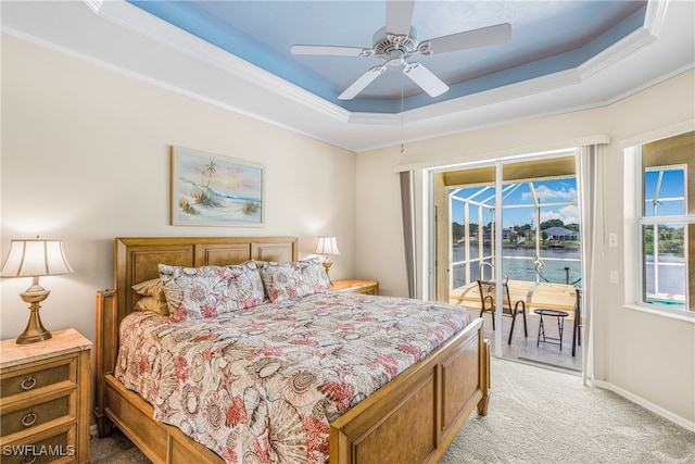 bedroom featuring a water view, ceiling fan, a raised ceiling, access to exterior, and light colored carpet