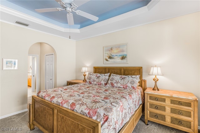 carpeted bedroom featuring ceiling fan, a closet, crown molding, and a tray ceiling