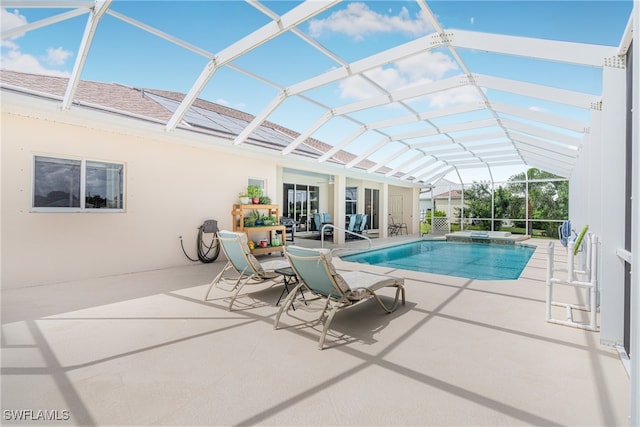 view of swimming pool with an in ground hot tub, a patio, and glass enclosure