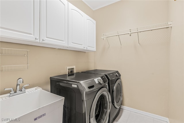 laundry room featuring cabinets, sink, and washing machine and clothes dryer