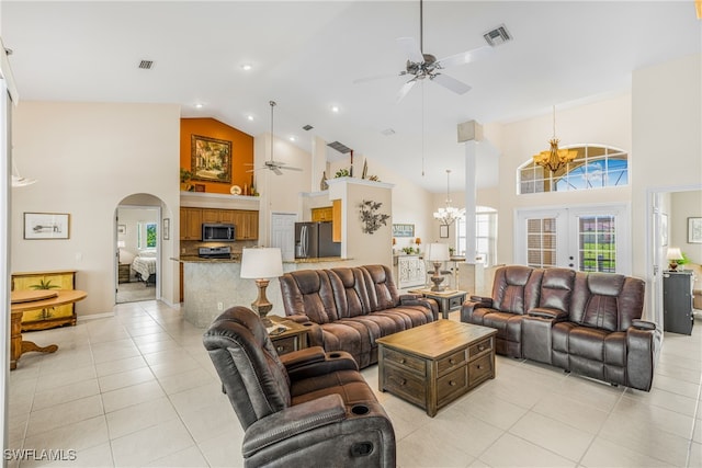 tiled living room featuring ceiling fan with notable chandelier, high vaulted ceiling, and french doors