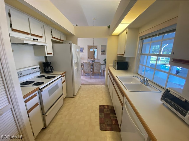 kitchen with white appliances, sink, a chandelier, and white cabinets