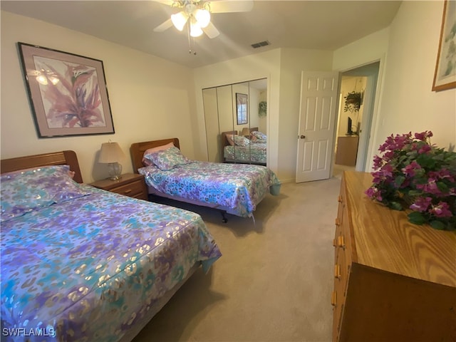 carpeted bedroom with ceiling fan and a closet