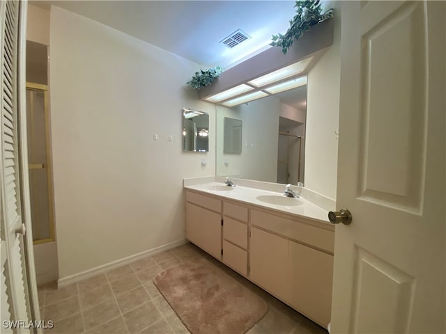 bathroom with enclosed tub / shower combo, vanity, and tile patterned floors