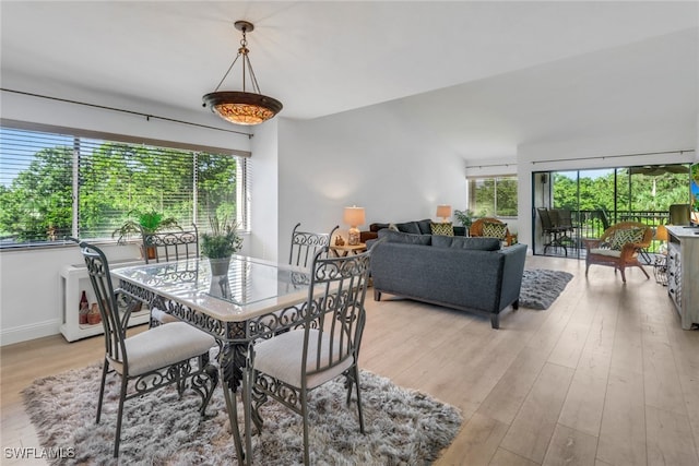 dining area featuring light wood-style flooring and baseboards