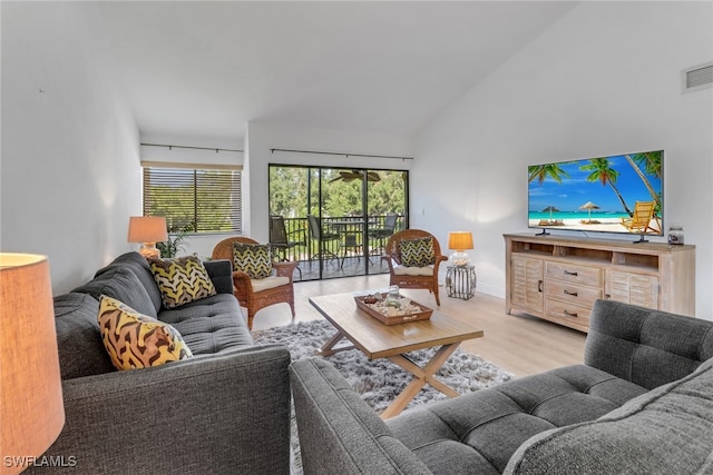 living room with high vaulted ceiling, plenty of natural light, and light hardwood / wood-style floors