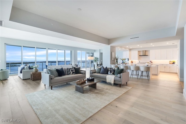 living room featuring light hardwood / wood-style floors and a water view