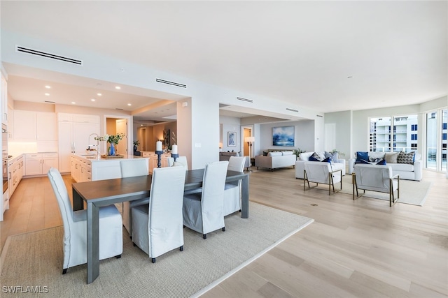 dining area with light hardwood / wood-style flooring and sink