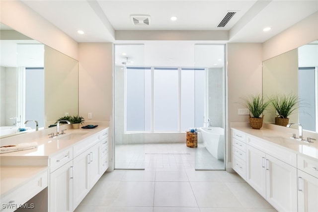 bathroom with vanity, a bathing tub, and tile patterned floors