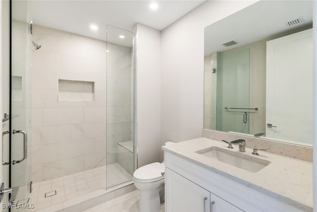 bathroom with a shower with shower door, vanity, and toilet