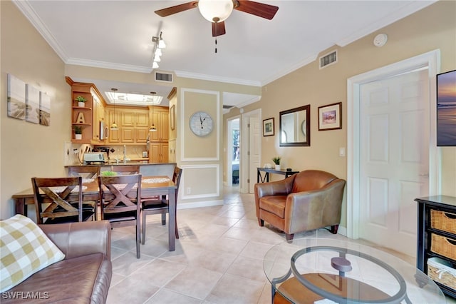 tiled living room with track lighting, ceiling fan, and crown molding