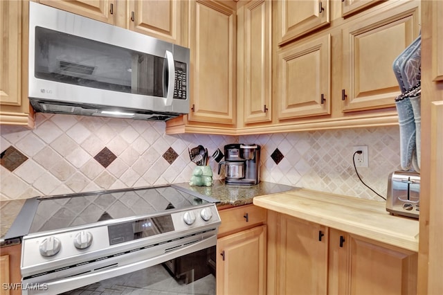 kitchen featuring wooden counters, light brown cabinetry, backsplash, and stainless steel appliances