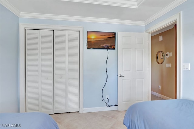 tiled bedroom featuring ornamental molding and a closet