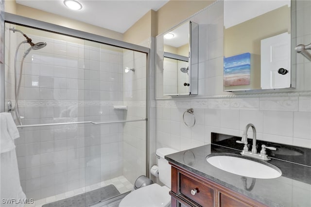 bathroom featuring decorative backsplash, vanity, toilet, and walk in shower