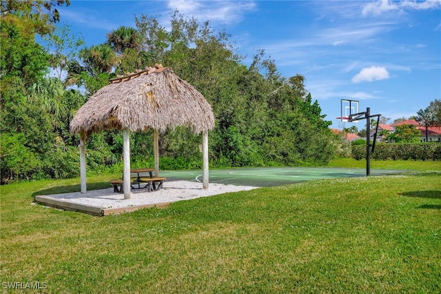 view of community featuring a lawn and basketball court