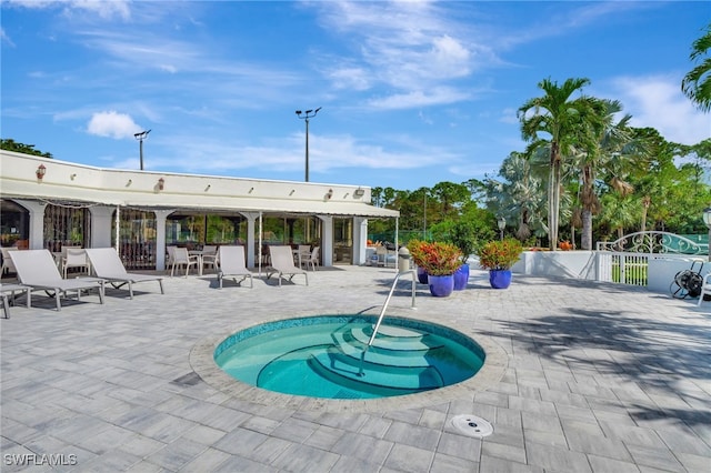 view of swimming pool featuring a community hot tub and a patio