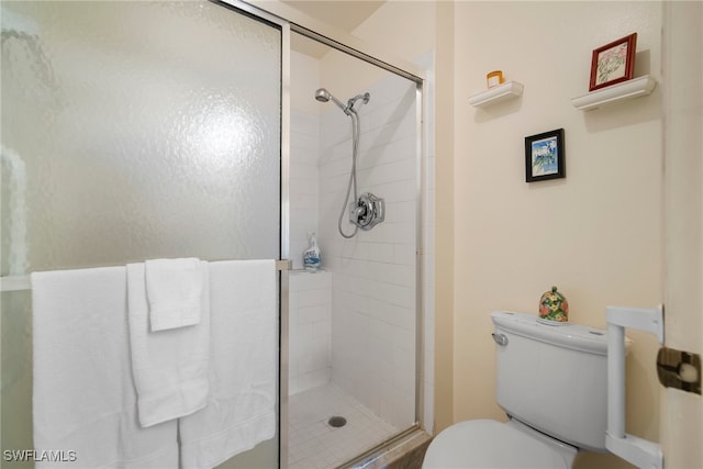 bathroom with toilet and a shower with shower door