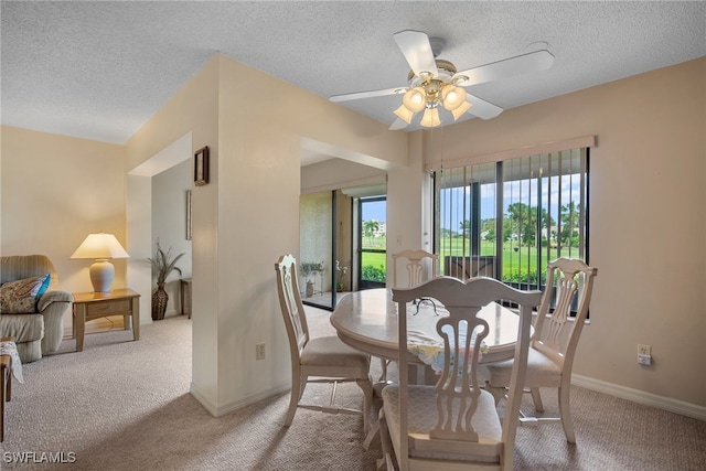 carpeted dining space featuring a textured ceiling and ceiling fan