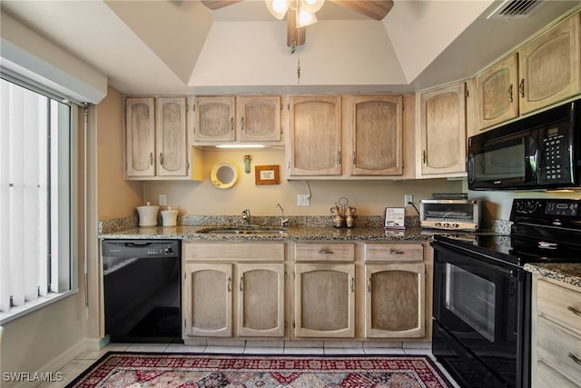 kitchen featuring dark stone countertops, light brown cabinets, lofted ceiling, and black appliances