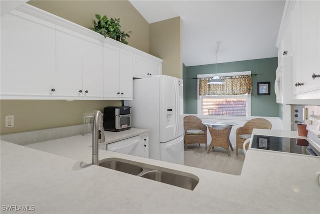 kitchen featuring white cabinets, pendant lighting, white fridge with ice dispenser, and sink