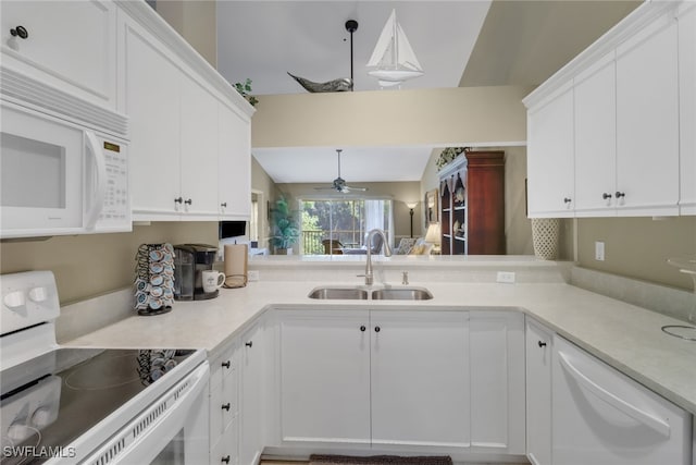 kitchen featuring white cabinets, white appliances, vaulted ceiling, and sink