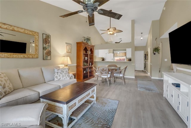 living room featuring high vaulted ceiling and light wood-type flooring