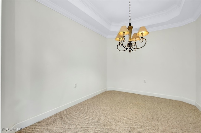 spare room with an inviting chandelier, carpet flooring, ornamental molding, and a raised ceiling