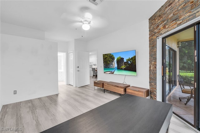 unfurnished living room featuring ceiling fan and light wood-type flooring