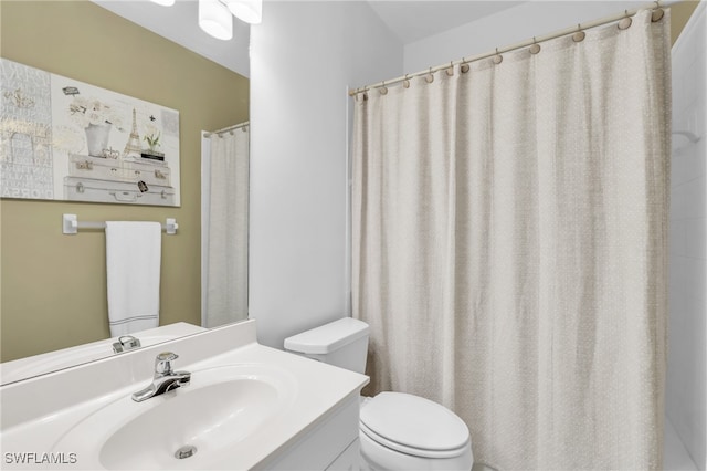 bathroom featuring toilet, curtained shower, and vanity