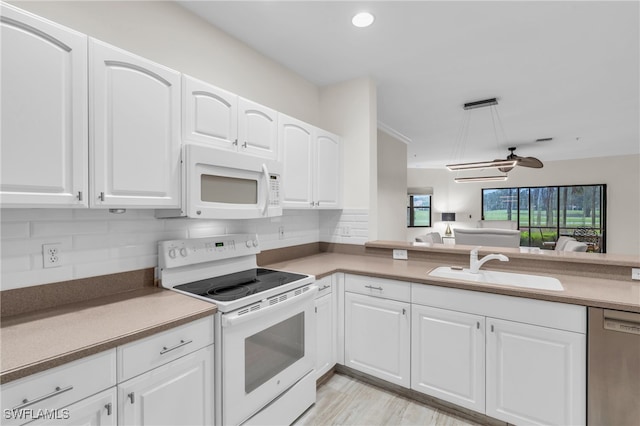 kitchen featuring white cabinetry, sink, and white appliances