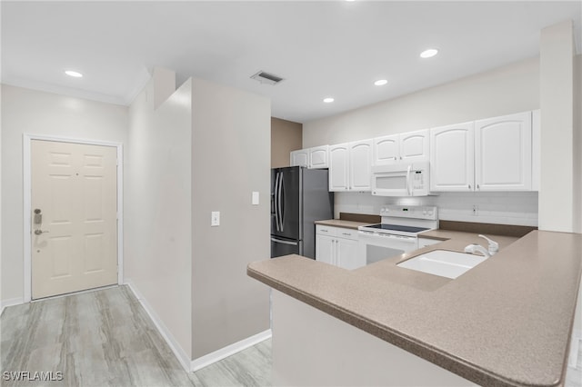 kitchen with kitchen peninsula, white cabinets, light hardwood / wood-style floors, sink, and white appliances