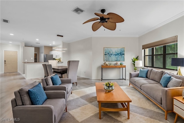 living room featuring crown molding and ceiling fan