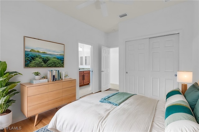 bedroom with light hardwood / wood-style flooring, a closet, ensuite bath, and ceiling fan