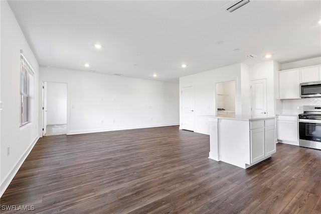 kitchen featuring white cabinetry, a center island, stainless steel appliances, dark hardwood / wood-style floors, and backsplash