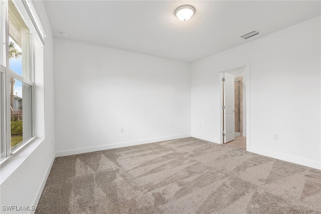 carpeted spare room featuring a healthy amount of sunlight