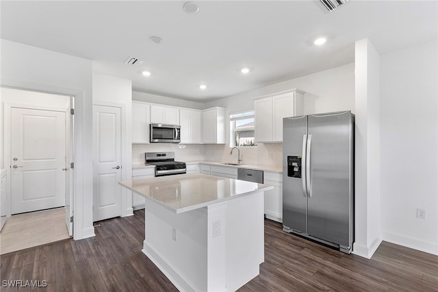 kitchen featuring white cabinetry, a center island, sink, dark wood-type flooring, and stainless steel appliances