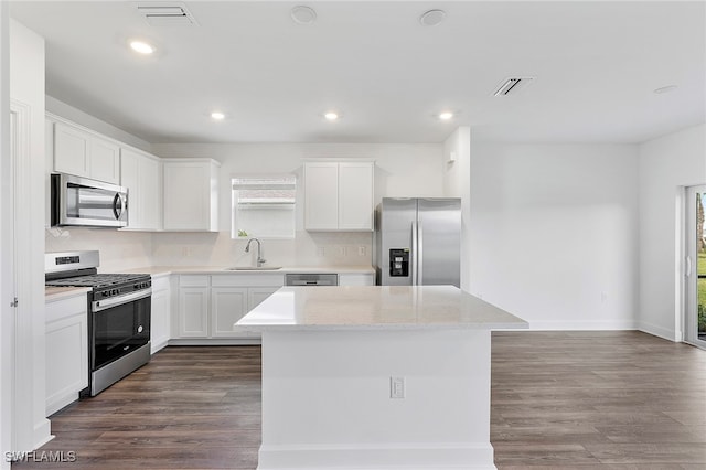 kitchen with a healthy amount of sunlight, sink, a center island, and stainless steel appliances