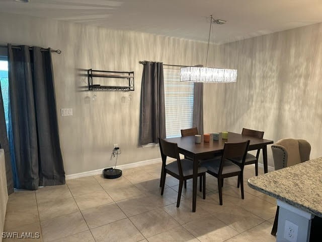 tiled dining space with an inviting chandelier