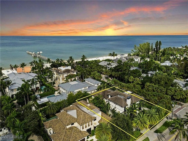 aerial view at dusk featuring a water view