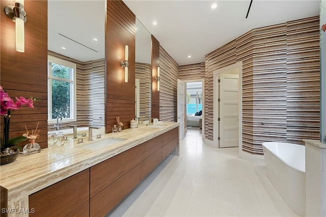 bathroom with plenty of natural light, a tub, and vanity