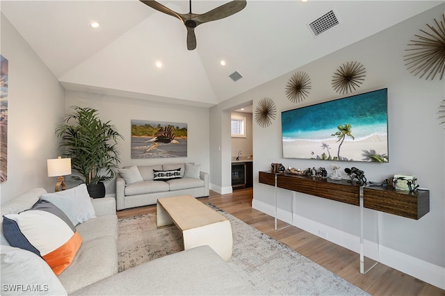 living room with ceiling fan, lofted ceiling, and hardwood / wood-style flooring