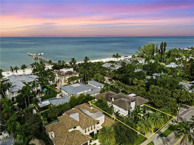 aerial view at dusk featuring a water view